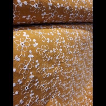 Coton moutarde broderie fleurs blanches 136cm